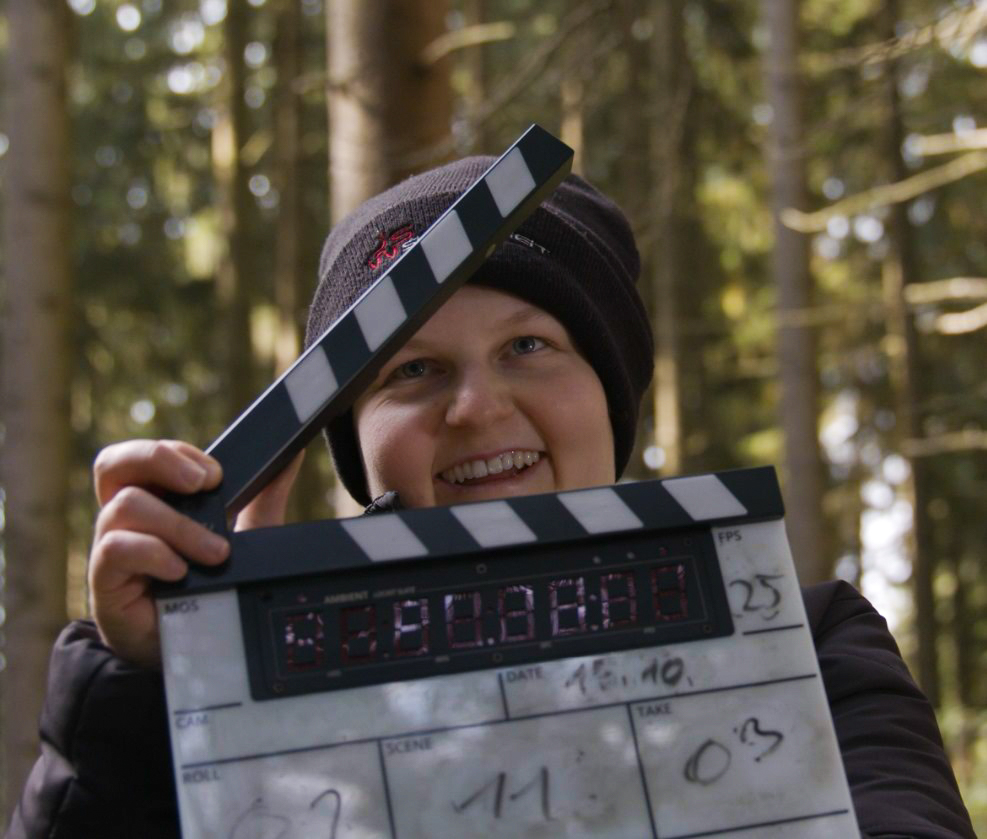 Vivian Wolf beim Dreh eines Filmes mit einer Filmklappe in der Hand.